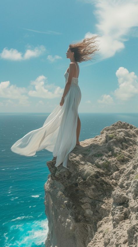 Elegant Cliffside Pose: A woman in a flowing white dress stands poised on a cliff overlooking the vast ocean. #woman #cliff #ocean #elegance #breeze #aiart #aiphoto #stockcake ⬇️ Download and 📝 Prompt 👉 https://ayr.app/l/fJRd Someone Falling Off A Cliff, Photo With Dress Aesthetic, Woman Figure Reference Drawing Poses, Beach Cliff Photoshoot, Girl Falling Off Cliff, Flowing Dress Photography, Dress Flowing In The Wind, Cliff Photoshoot, Sitting On Cliff