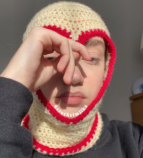 A girl wearing a cream coloured heart cut out crochet ski mask with red lining on the rim of the heart cut out and as well as the opening to the mask. Crochet Heart Balaclava, Crochet Full Face Mask, Free Crochet Ski Mask Patterns, How To Crochet A Ski Mask, How To Style Balaclava, Bonnet Pattern Crochet, How To Crochet Balaclava, Crochet Heart Hat, Crochet Mask Pattern Free