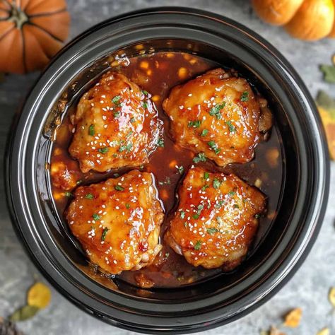 Crockpot Spicy Honey Sriracha Chicken: Four juicy chicken thighs glazed with a shiny, dark red honey sriracha sauce, garnished with parsley and sesame seeds in a crockpot. Crockpot Asian Chicken, Crockpot Fall Recipes, Chicken Thighs Crockpot, Easy Crockpot Chicken Recipes, Crockpot Asian, Pork Green Chile, Glazed Chicken Thighs, Smoked Paprika Chicken, Bbq Pulled Chicken Sandwiches