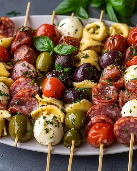 Delicious Italian Antipasto Skewers with marinated tortellini, mozzarella, salami, olives, and fresh basil. Perfect for parties! Italian Theme Appetizers Dinner Parties, Marinated Tortellini Skewers, Italian Horderves Appetizers, Marinated Olives Appetizer, Italian Antipasto Skewers, Marinated Mozzarella Balls Appetizers, Make Ahead Italian Appetizers, Tortellini Kabobs Antipasto Skewers, Olives Appetizer Ideas