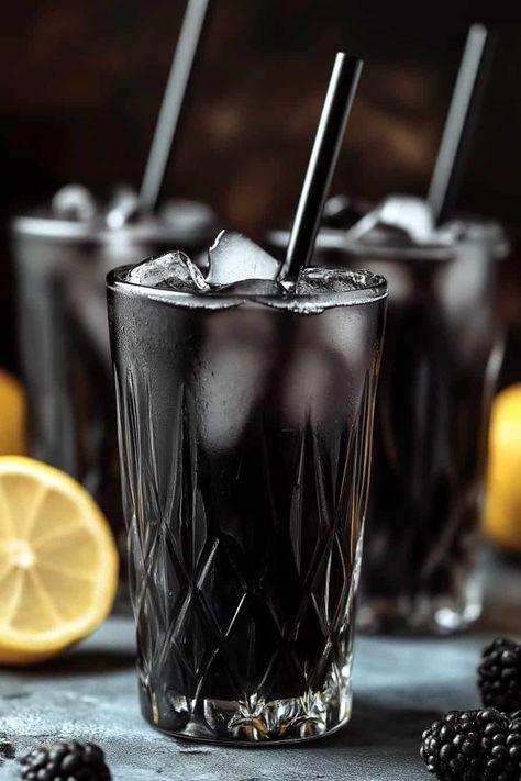 Three glasses of Black Charcoal Lemonade with black straws and ice cubes, garnished with blackberries, with lemon halves in the background. Spooky Halloween Food Ideas, Easy Halloween Food Ideas, Bartending Drinks, Charcoal Lemonade, Pineapple Lemonade Punch, Halloween Themed Desserts, Blue Hawaiian Punch, Halloween Themed Snacks, Virgin Pina Colada