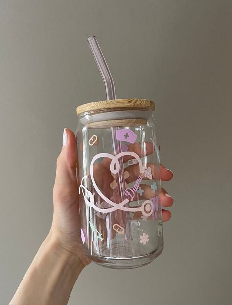 Custom Nurse Appreciation Libbey Glass with Bamboo Lid and Pink Straw  What does every nurse need to do their job?? An adorable personalized glass to keep their nurse fuel in!! ️ As a nurse that's constantly on the move, they don't have time to enjoy their coffee hot, so iced coffee it is! 👏🏼 This cute and trendy glass makes for a great gift for that special someone, friend, coworker, or even your favorite nurse! Fill it up with some chocolate or candy, and it is ready to be given as a lovely Nurse Glass Cup Ideas, Nurse Glass Cup, Personalized Nurse Gifts, Libbey Glasses Ideas, Mug Ideas Design, Nurse Cups, Personalized Cups Diy, Tumbler Cricut, Glass Tumbler With Straw