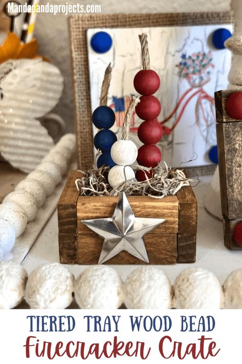 Craft and decorate your tiered tray for Memorial Day and 4th of July with a mini Patriotic Wood Bead Firecracker Crate made with Dollar Tree Jenga Blocks! This little Americana DIY is sure to make a bang! Handmade Patriotic Beaded Bracelets For 4th Of July, Diy Firecracker Decor, Patriotic Beaded Bracelets For Independence Day, Dollar Tree Patriotic Crafts, Patriotic Wood Bead Garland, Patriotic Crafts Diy, Fourth Of July Fireworks, Patriotic Tiered Tray, Jenga Blocks