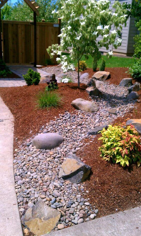 A Dry Creek Bed with Mulch Dry Creek Bed Landscape Front Yards, Dry Stream Bed Landscaping, Dry Creek Bed Landscape, Rock Yards, Apartment Landscape, Garden Slope, Dry Riverbed Landscaping, Xeriscape Front Yard, Ornamental Horticulture