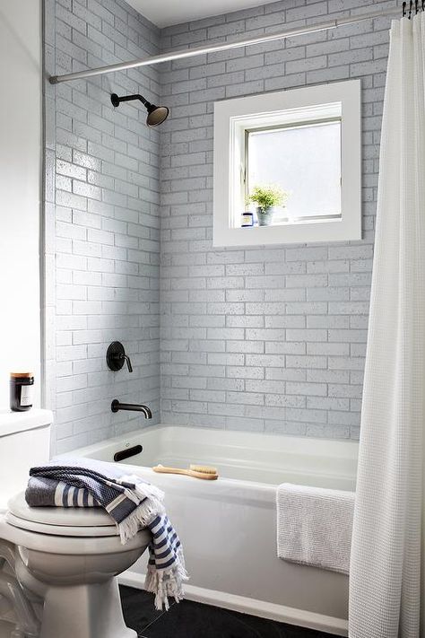 A white basketweave shower curtain hangs in front of a drop-in bathtub fitted with an oil rubbed bronze shower kit fixed to silver staggered surround tiles. Shower With Window, Brick Style Tiles, Rectangular Bathtub, Tub Design, Drop In Tub, Drop In Bathtub, Window In Shower, Rustic Vanity, Bathtub Tile