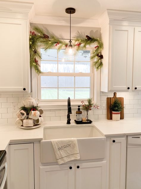 Christmas Lights Around Kitchen Window, Kitchen Window Holiday Decor, Christmas Kitchen Window Sill, Top Of Kitchen Cabinet Christmas Decor Ideas Modern, Above The Sink Christmas Decor, Wreath Above Sink, Wreath Kitchen Window, Garland Over Kitchen Sink, Garland In Kitchen Window