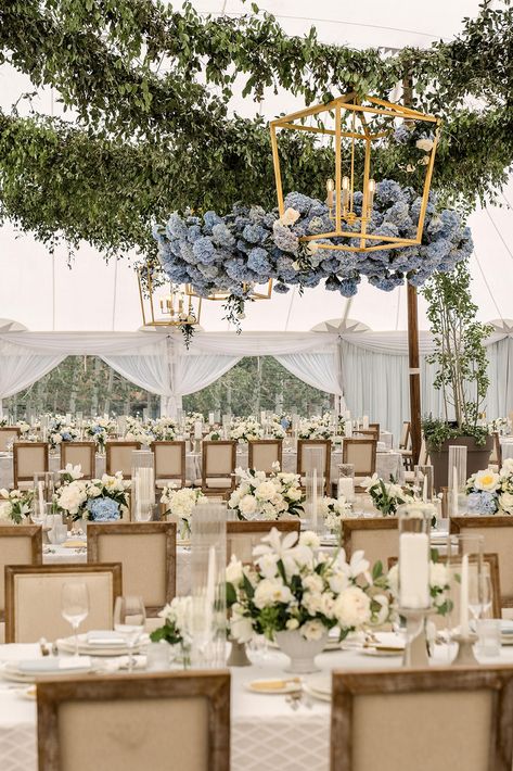 Transform your wedding reception with timeless elegance. This stunning setup features lush greenery, cascading blue hydrangeas, and luxurious gold chandeliers for a romantic, elevated look. Paired with classic white florals and elegant seating, this design brings sophistication and charm to any tented celebration. Perfect for garden-inspired or formal weddings! Blue Hydrangea Wedding Centerpieces, Hydrangea Wedding Centerpieces, Hydrangea Centerpiece Wedding, Gold Chandeliers, Blue Hydrangea Wedding, Elegant Wedding Reception, Blue Hydrangeas, Hydrangeas Wedding, Floral Centerpiece