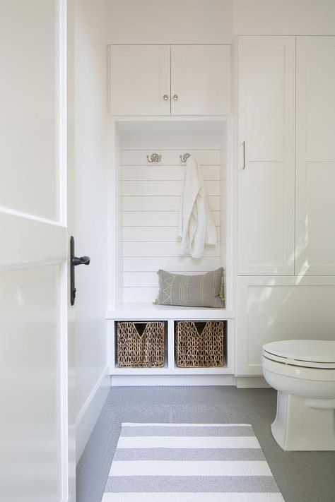 Bathroom in mudroom features an under window toilet alongside a white and gray stripe rug layered atop a gray penny tiled floor. Pool Towel Storage, Pool House Bathroom, Penny Tile Floors, Window Mudroom, Shiplap Backsplash, Tiled Floor, Stripe Rug, Pool Bathroom, Mud Rooms