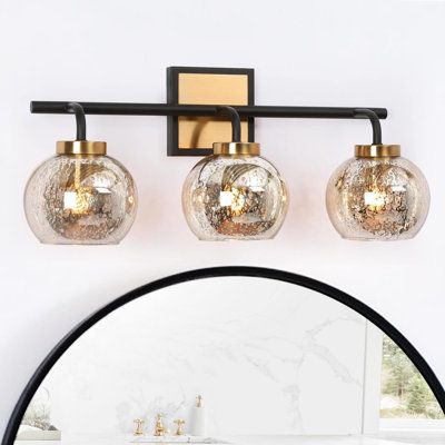 The highlight of this bathroom vanity light is the unique mercury glass shade. Whether you use white light or warm light, it will show very beautiful patterns when the light is turned on. The combination of black and vintage brass is suitable for a variety of styles such as modern, farmhouse, mid-century modern, etc. making your bathroom look with understated colors without being monotonous. Compatible with an E26 base and max 40W light bulbs, this modern wall light will bring sufficient lightin Farmhouse Vanity Lights, Glass Light Fixtures, Modern Bathroom Vanity Lighting, Black And Gold Bathroom, Brass Vanity Light, Modern Vanity Lighting, Black Vanity Bathroom, Black Vanity Light, Vanity Light Fixtures