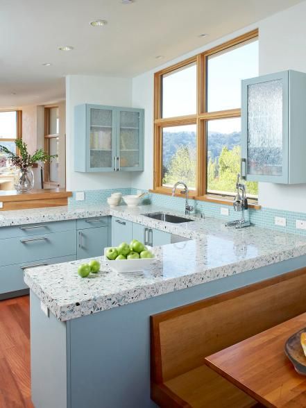 The eco-friendly choice, recycled countertops come in a variety of sustainable materials, including concrete, glass, paper, composite and plastic. Usually a mix of pre- and post-consumer products, recycled countertops are available in a wide range of colors and textures. This beachy kitchen by Massucco Warner Miller features IceStone terrazzo which is composed of recycled glass, Portland cement and resin for a durable, low-maintenance surface. Blue Countertops, Hgtv Kitchens, Coastal Kitchen Design, Minimalist Dekor, Outdoor Kitchen Countertops, Kitchen Design Color, Kabinet Dapur, Kitchen Countertop Materials, Glass Countertops