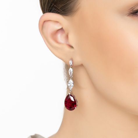 Add a touch of regal elegance to your ensemble with the Zara Teardrop Ruby Earrings in Silver, featuring lab-created rubies. These striking earrings boast a pear-shaped ruby at their heart, set against a backdrop of ornate silver, and are accentuated by a row of three marquis-shaped simulated diamonds for that extra sparkle.  Rubies, with their deep red hue, symbolize passion, courage, and love. Perfect for a glamorous night out or adding a bold statement to your daily attire, these earrings are sure to turn heads. Elevate your jewellery collection with the addition of these mesmerizing ruby earrings and let your style reflect your boldness and elegance. Handcrafted in 925 Sterling Silver. Lab-created Ruby. Simulated Diamonds.  Care Instructions:  To maintain your jewellery, wipe gently wi Regal Elegance, Silver Lab, Formal Jewelry, June Birthstone Jewelry, Maid Of Honour, Ruby Earrings, Pearl Jewellery Earrings, Red Earrings, Ruby Gemstone