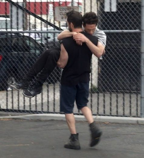 Two Men, Fence, Cars