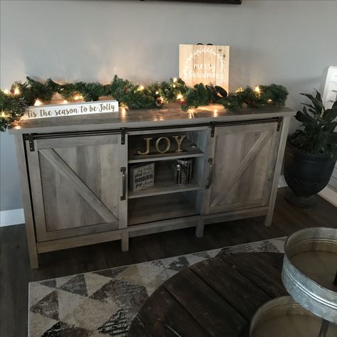 Christmas Decorated TV Stand with garland  #Joy #HobbyLobby Decorated Tv Stand, Garland Tv Stand, Decorate Tv Stand, Tv Stand Christmas, Tv Stand Christmas Decor, Decorated Garland, Home Tv Stand, Christmas Decorations Apartment, Tv Stand Decor