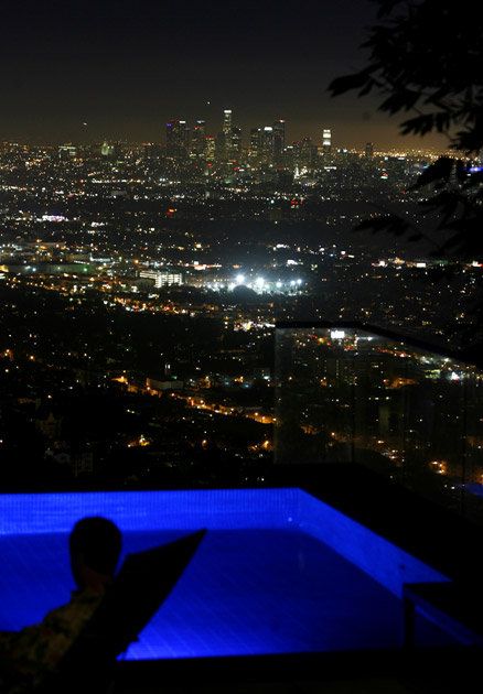 The pool is suspended atop a 40-foot-long platform beneath which is an enclosed screening room with a downtown skyline view. Hollywood Hills View, Nights Like This, Hollywood Hills Aesthetic, California Pool, Hillside Pool, House In The Hills, Business Tycoon, Architecture Unique, Novel Ideas