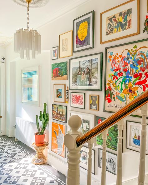 Transformation Tuesday in our hallway! 🌟 When we first stepped into this house, the hallway instantly captured my heart—so welcoming and warm. We brightened it up with white walls to enhance the light and maximize the feel of the space. We chose @karndean_uk for the flooring—a fantastic decision as it’s a breeze to keep clean! The walls are adorned with art we’ve collected over the years, making every view a gallery. No matter the weather outside, it’s always bright and welcoming here. Swipe ... Gallery Wall Entrance Hall, Art Wall Hallway, Diy Hallway Wall Decor, Picture Frame Hallway Ideas, Colourful Picture Wall, Pictures In Entryway, Colourful Entryway Ideas, Eccentric Hallway, Colourful Photo Wall