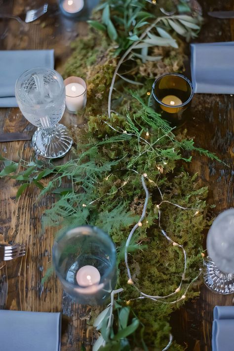 Lovely enchanted woods wedding tablescape with moss and fern runner, lights Moss Wedding Decorations, Woods Theme Wedding, Wedding Centerpieces With Moss, Forest Theme Table Setting, Moss Runner Wedding, Moss Themed Wedding, Moss Tablescape Wedding, Moss Table Runner Wedding, Moss Table Wedding