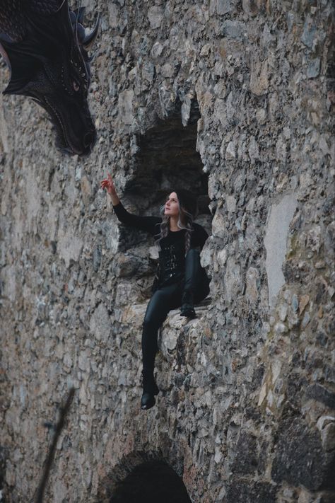 Girl in black leather outfit sitting on the window of old castle point right hand up toward a black dragon’s head Violet Sorrengail Cosplay, Riders Quadrant, Wing Cosplay, Violet Sorrengail, Iron Flame, Book Costumes, Fourth Wing, Dragon Rider, Book Writing