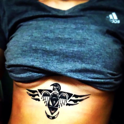 Awesome thunderbird under the breasts for a girl. Color: Black. Tags: Awesome Aztec Tattoos For Women, Aztec Tattoo For Women, Thunderbird Aesthetic, Thunderbird Tattoo, Teacup Tattoo, Phoenix Bird Tattoos, Mayan Tattoos, Aztec Tattoos, Aztec Tattoo Designs