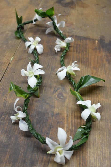 A nice and dressed up ti leaf lei, the orchids can vary in color from white to purple, red, orange, yellow, pink or purple. Flower Lei Diy, Wedding Leis, Ti Leaf Lei, Lei Diy, Orchid Lei, Wedding Lei, Ti Leaf, Lei Making, Tropical Honeymoon