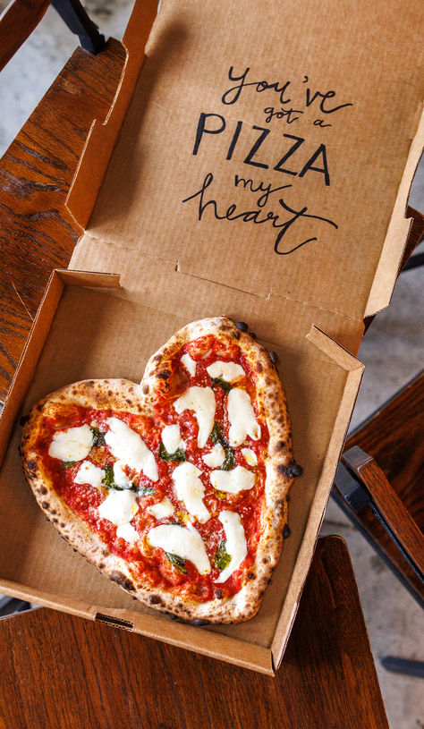 A heart-shaped pizza in a cardboard box on a wooden table. The text on the pizza says "you've got a pizza heart". Star Shaped Pizza, Pizza Themed Bachelorette Party, Pizza Shop Ideas, Pizza Marketing Ideas, Pizza Truck Wedding, Pizza Party Aesthetic, Pizza Night Aesthetic, Shaped Pie, Pizza Valentine