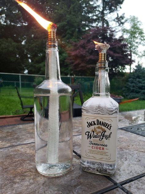 DIY Tiki Torches from recycled alcohol bottles Diy Tiki Torch, Diy Whiskey, Empty Liquor Bottles, Diy Outdoor Lighting, Garden String Lights, Tiki Torches, Alcohol Bottles, Outdoor Diy Projects, Backyard Diy Projects