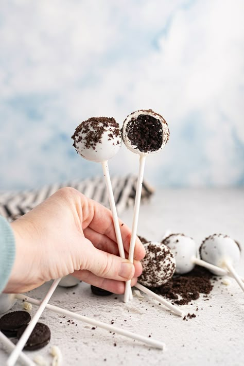 A hand holding two cookies and cream cake pops. Starbucks Cookies And Cream, Cookies And Cream Cake Pops, Starbucks Cookies, Starbucks Cake Pops, Cake Pop Recipes, Starbucks Cake, Cooking With Karli, Cranberry Bliss Bars, Cheaper By The Dozen