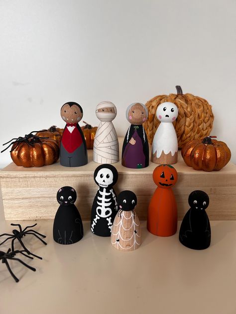 Beautiful, eco-friendly hand painted peg dolls created using high quality beech wood and non-toxic acrylic paint. This set includes a ghost, vampire, mummy, pumpkin, skeleton, witch, cat, bat and a spider. All pegs are 6.5cm other than the cat, bat and spider which are 5cm.  Warning - please note that due to its size, the 5cm dolls are not suitable for children under 3 years due to small parts choking hazard.  Pegs are sealed using a non-toxic sealant. To clean, simply wipe down with a clean, da Halloween Figurines Diy, Wooden Figures, Wooden Doll, Vampire Painted Pumpkin, Cat Peg Doll, Halloween Peg People, Halloween Peg Dolls, Ghost Peg Doll, Peg Dolls Halloween