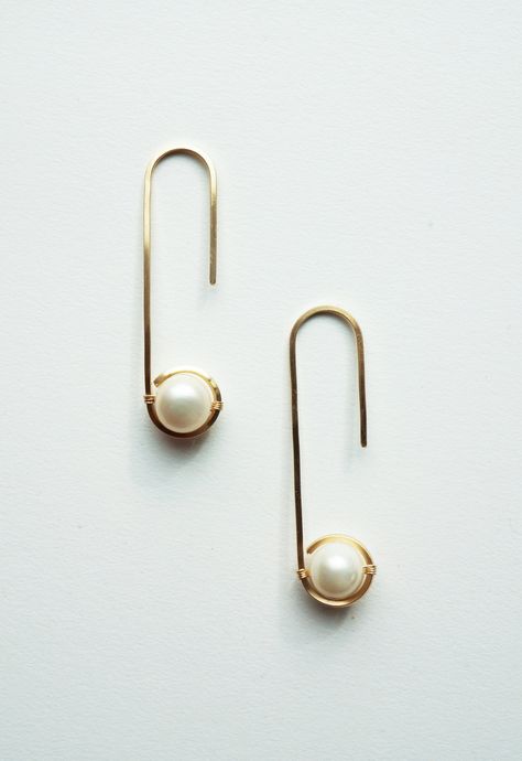 "Aperta is the latin word for \"open.\" These simply beautiful oval hoop earrings highlight genuine saltwater pearls by square wire hugging them. Handmade Gold filled or sterling silver square wire Genuine semi-precious cultured Biwa pearls Size: 1-3/4\"L x 7/16\"W Please Note: Due to the natural state of pearls used by Brave Chick, each piece will vary. The naturally occurring variations such as shape, color, shading, color concentration, thickness, texture, are to be expected. These difference Minimalist Wire Earrings, Color Shading, Handmade Hoop Earrings, Latin Word, Oval Hoop Earrings, Biwa Pearls, Saltwater Pearls, Wire Jewelry Designs, Minimal Earrings