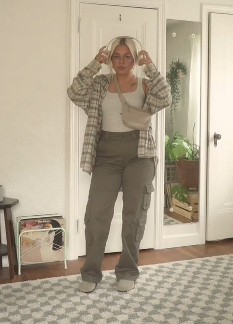 A girl with earphones wearing cargo pants and tanktop. Cute pose and aesthetic outfit inspo Green Cargo Pants Women Outfit Ideas, Carpenter Pants Outfit Winter, Chocolate Brown Cargo Pants Outfit, Cargo Pants And Tshirt Outfit, Cargo Pants Inspo Outfit, Midsize Cargo Pants Outfit, Fall Outfits Cargo Pants, Women’s Cargo Pants Outfit, Cargo Pants Outfit Spring