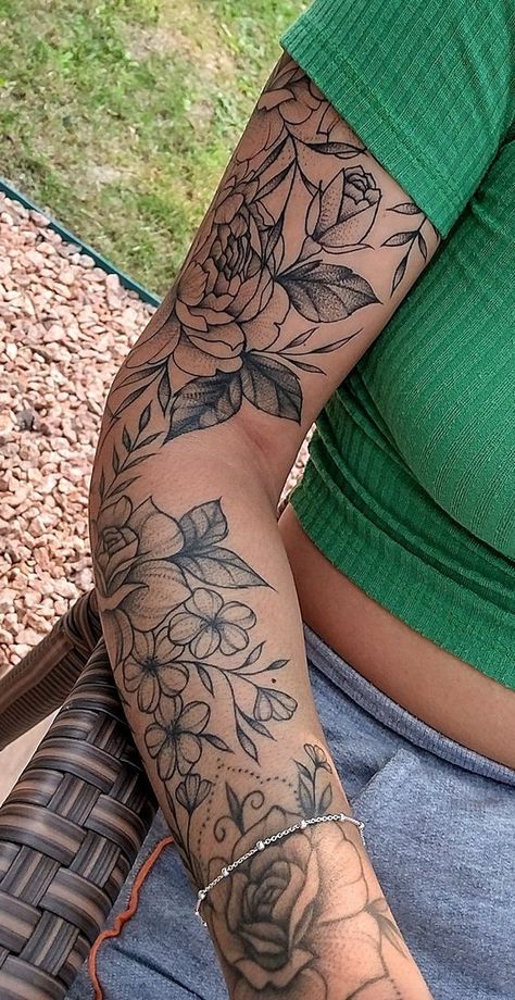 9998 Close-up of a woman's arm with detailed floral tattoo, wearing a green top and gray pants, sitting outdoors on a wicker chair. | Sky Rye Design Around Arm Tattoo, Arm Sleeve Tattoos For Women, Tattoo Leg, Floral Tattoo Sleeve, Forearm Tattoo Women, Flower Tattoo Sleeve, Leg Tattoos Women, Pretty Tattoos For Women, Feminine Tattoo