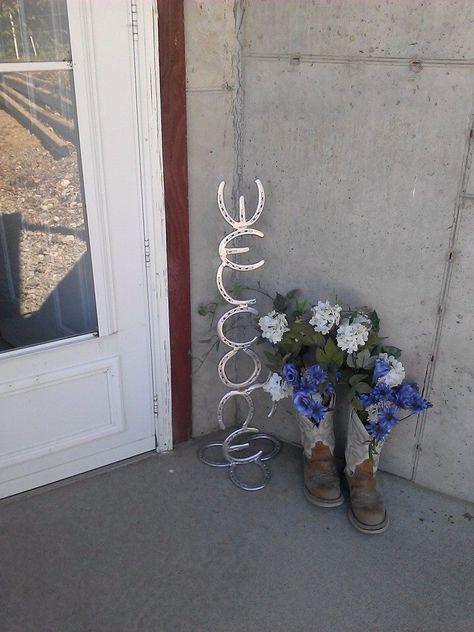 My friend Stephanie designed this from her old riding boots. Love the horse shoe sign. Horseshoe Welcome Sign, Rod Iron Decor, Barn Landscaping, Shoe Sign, Horseshoe Wine Rack, Horseshoe Ideas, Horseshoe Crafts Projects, Homemade Things, Diy Recycled Projects