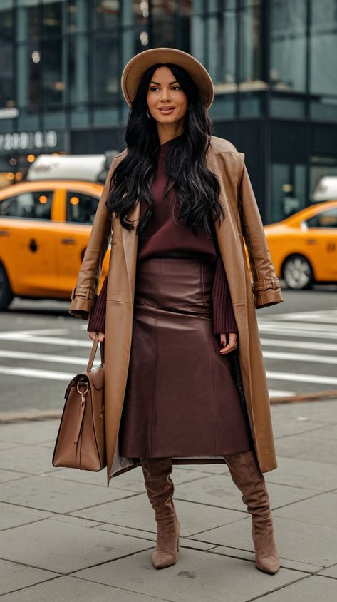 Embrace the urban elegance of fall 2024 with this stunning outfit! This stylish woman showcases a sleek leather mid-thigh skirt that perfectly pairs with trendy knee-high boots, creating an effortlessly chic silhouette. A fashionable brown trench coat layered over a cozy burgundy sweater adds warmth and sophistication, making it ideal for crisp city days. Large bag not only enhances the look but is also perfect for carrying essentials while on the go. #fallfashiontrends #falloutfit #autumn Trench Skirt Outfit, Cognac Suede Boots Outfit, Burgundy And Tan Outfit, Brown Leather Long Coat For Fall, Burgundy And Brown Outfit, Brown And Burgundy Outfit, Brown Leather Skirt Outfit Fall, Fall Brown Faux Leather Outerwear, Burgundy Leather Skirt Outfit