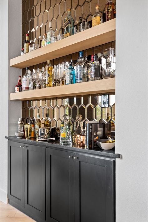 Custom wet bar design. Liquor cabinet. Black millwork design. Industrial pendant lights. Wood floating shelves. Liquor display shelving. Mirror backsplash. Black countertop. Bar Shelves Ideas Liquor, Wet Bar With Floating Shelves, Bar Shelves Ideas, Bar With Floating Shelves, Wet Bar Backsplash, Wet Bar Design, Millwork Design, Liquor Display, Wet Bar Designs