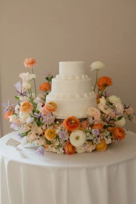 Wedding Flower Pots Outdoor, Wedding Cake Surrounded By Flowers, Wild Flower Cake Wedding, Minimalist Floral Wedding Cake, Wedding Cake Wild Flowers, Wedding Cake With Flowers Around Base, Pastel Flower Wedding Cake, Simple Colorful Wedding Cake, Flowers Around Wedding Cake