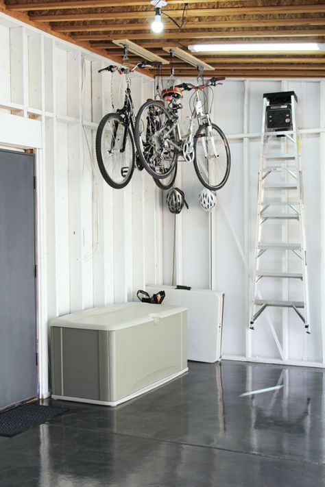 Hang bikes from the garage ceiling with an easy bike pulley system for bike storage. Bike Storage Pulley System, Storing Bikes In Garage, Bike Storage Garage Ceiling, Track Shelving, Garage Organization Shelves, Garage Organizing, Bike Storage Garage, Garage Ceiling, House Organization