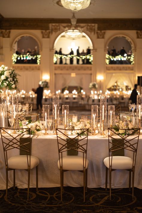 Rectangular guest table with arrangements of flowers and gold candlesticks to create an elevated winter wedding design. PC: Ann Coen https://www.anncoen.com/photography High Low Candles Wedding, Wedding Table Gold Candlesticks, Taper Candle Centerpiece Wedding Long Table, Glass House Wedding Receptions, Long Table Flowers, Wedding Reception With Candles, Candlelight Wedding Reception, Candlelit Wedding Reception, Gold Candlesticks