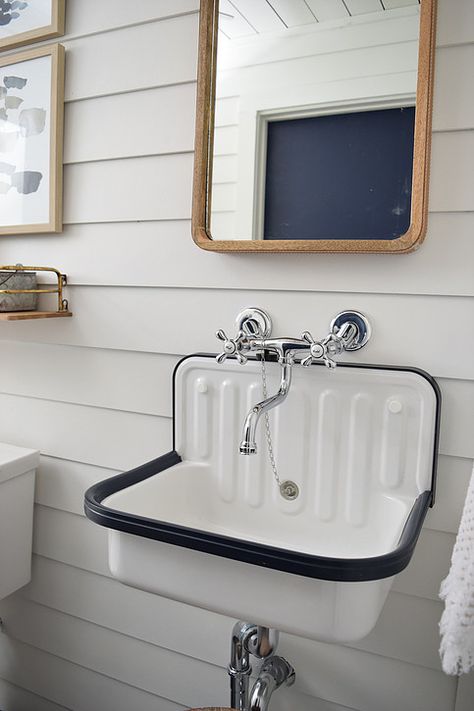 Modern farmhouse basement bathroom. Chrome wall mount faucet, vintage inspired industrial wall mount utility sink, leather wrapped wood mirror and white "shiplap" walls. Alape Bucket Sink, Farmhouse Basement, Bathroom 2023, Inexpensive Bathroom Remodel, Small Basement Bathroom, Affordable Bathroom Remodel, Bathroom Chrome, Bucket Sink, Bungalow Decor