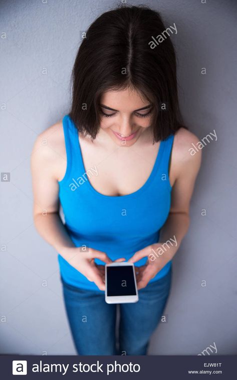 Download this stock image: Top view portrait of a happy woman using smartphone over gray background. Wearing in blue t-shirt and jeans. - EJW81T from Alamy's library of millions of high resolution stock photos, illustrations and vectors. Top Down View Perspective, Head Top View, Top View Reference, Perspective Practice, Body Practice, Three Point Perspective, Body Paintings, Drawing Anatomy, Happy Woman