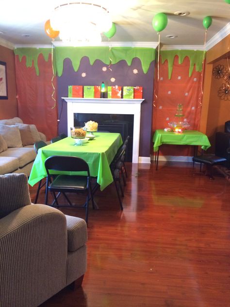 This was my set up for the KCA party...Covered my book shelves with cheap plastic table cover, cut out a slime design and stuck in on top. Blew up some balloons and got out my daughters lava lamp which I displayed next to the goody bags on my fireplace mantel. For a little extra effect I set up a drinking fountain with green Hawaiin Punch..... The kids loved it! 90s Nickelodeon Party, Nickelodeon Party, Slime Party Table, Diy Slime Bar Party, Nickelodeon Slime Party, Slime Time Birthday Party, Slime Themed Birthday Party Treats, Goosebumps Party, Mad Scientist Birthday