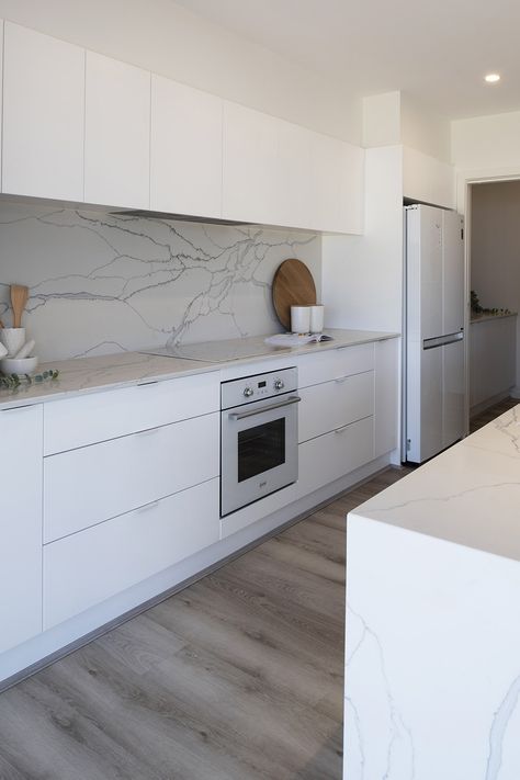 Fresh white kitchen with white marble splashback and countertop. Marble Look Splashback Kitchen, Marble Splashback, Marble Benchtop Kitchen, White Kitchen Bench, Split Level Home Designs, Montgomery Homes, Marble Benchtop, Scandi Kitchen, Galley Kitchens