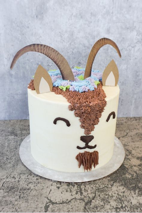 I make this adorable goat cake for an Easter gathering! It was made with carrot cake and vanilla frosting, with some chocolate frosting decorations. The flowers and leaves on top were made with natural food coloring, and the ears and horns are custom toppers that I made!   #customcake #goatcake #naturalfoodcoloring #chocolatefrosting #vanillafrosting #carrotcake #goats #goat #mtnsidebakery #cakedecorating #cakeideas #birthdayideas #birthdaycake #kidsbirthday #birthdayparty Goat Party Theme, Goat Party Ideas, Goat Cupcakes, Goat Cake Ideas, Lamb Cake Ideas, Goat Birthday Party, Goat Cake, Goat Party, Cake Sculptures