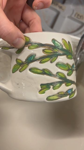 Maya Rumsey on Instagram: "Glazing. The green tint is from the wax resist I use. Everything that will be coming with me to NCECA is finished or in the kiln! I’ll be selling my work at the @impotsterspopup Thursday night. There will be pottery, beer (it’s at @rhinegeist), food, live music and just a good time! I hope you can come! —————- #pottery #clay #nceca2023 #nceca #impotsterspopup #ceramics #mugshotmonday #muglife #coffee #art #contemporarycraft" Pottery Wax Resist Decoration, Wax Resist Ceramics, Wax Resist Pottery, Underglaze Mug, Underglazed Mug, Underglaze Transfer Mug, Wax Resist, Pottery Glazes, Contemporary Crafts