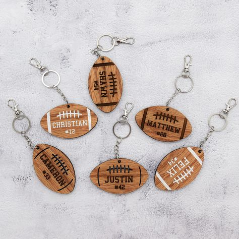 This wood keychain is a wonderful way to add personalization to your football player's bag. Whether it's their school bag or gear bag, let them represent themselves while looking stylish! Perfect for your football superstar! 3 football designs to choose from and you can get either a horizontal or vertical setup. Design A - all engraved Design B - Personalization is engraved and the design is laser cut Design C - engraved then painted white. The back has no design but is stained as well. Perfect School Bag Keychain, Football Bag Tags, Football Locker Decorations, Forge Projects, Football Team Gifts, Football Basket, Woman Costumes, Football Bag, Senior Football