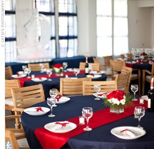 On the reception tables, bright red table runners laid atop classic navy linens. To complement the nautical décor, the couple used red and white roses for centerpieces. Nautical Reception Decor, Usmc Wedding, Marine Corps Wedding, Decoration Communion, Patriotic Wedding, Marine Wedding, Red Wedding Theme, Nautical Wedding Theme, Elegant Wedding Reception