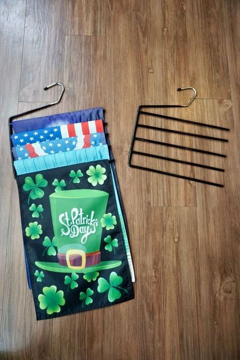 This idea is so simple that a tutorial is unnecessary.Basically it's:Multiple garden flags + repurposed pants hanger = instant flag storage! You can see Steph talk about the garden flags and the stand we built at the 5:50 mark in this edition of Workshop Wednesday. The stand is PVC pipe with a concrete base. The flags are 12 x 18 inches. Grab a couple of these these pants hangers. They are perfect for holding flags that are 12 inches across and 18 inches long. #storage #flags Flag Display Ideas, Garden Flag Diy, Garden Flag Holder, Small City Garden, Pants Hangers, Flag Diy, Pants Hanger, Craft Supply Storage, Mother Daughter Projects