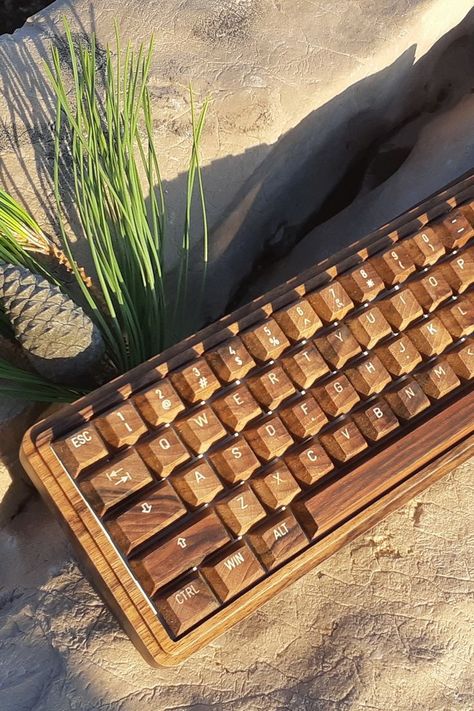 The Handmade Wooden Keyboard is the perfect way to show your love for nature. With its minimal design and rich natural wood grain, this mechanical keyboard is a pleasure to use. The dark walnut wood colors add a touch of excitement to your personal computing space! It's made from solid walnut wood. Each part of the keyboard is hand sanded and coated with an ecological oil that gives it durability while maintaining its natural appearance and feel. Wooden Keyboard, Walnut Wood Color, Desktop Setup, Computer Engineering, Wooden Products, Love For Nature, Key Caps, Wrist Rest, Computer Setup