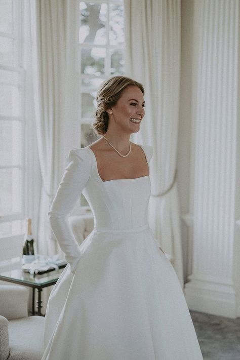 Bride wearing boned bodice square neck wedding dress with long sleeves, shoulder pads and pearl necklace and earrings Wedding Dresses Square Neck, Square Neck Wedding Dress, Hedsor House, Satin Wedding Dresses, Wedding Dress With Long Sleeves, Plain Wedding Dress, Pearl Wedding Dress, Neck Wedding Dress, Classy Wedding Dress