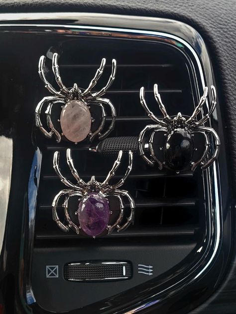 Add a touch of spookiness and healing to your car with these vent clips featuring spiders, essential oils, and gemstones. Infused with healing gemstones, these clips not only keep your car smelling fresh but also bring positive energy. Simply attach to your vent and let the magic begin!  Each vent clip freshy comes with its very own fragrance oil sample bottle (2 ml).  The oil will absorb into the felt pad and diffuse through the air vent once attached. Materials - This product is made of crystal and medal. Quantity - This listing is for one spider gemstone vent clip. Check out Shoreisfancy.etsy.com for similar products ✨️ Spider Car Decoration, Gothic Car Interior Decor, Car Vent Clip Air Freshener, Emo Car Interior Ideas, Kuromi Car Decor, Inside Car Ideas Aesthetic, Car Vent Accessories, Fall Car Accessories, Spooky Car Accessories