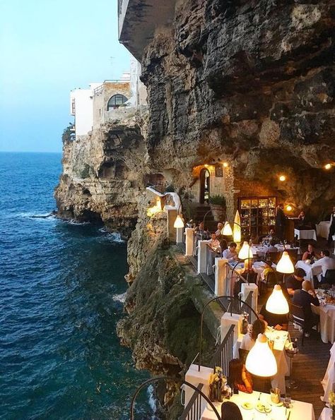 Italy’s Restaurant Built Inside a Cave Grotta Palazzese: Italy’s Restaurant Built Inside a Cave By Jennifer Dombrowski you can romantically dine in a candlelit cave overlooking the Adriatic Sea. The allure of that photo, a restaurant set in an unexpected location – who wouldn’t want to go there? I certainly did. It’s the Grotta Palazzese Summer Restaurant and it’s located in a hotel by the same name in Polignano a Mare in the Puglia region of Southern Italy. Aloita Resort, Halong Bay, Pompeii, Travel Inspo, Pretty Places, Lake Tahoe, Dream Destinations, Bari, Vacation Destinations