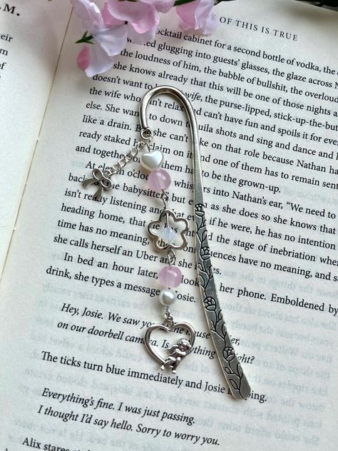 Handmade beaded bookmark featuring a coquette theme! Materials used include a silver metal bookmark hook, silver charms, and glass and plastic beads. Make your reading experience even cuter with this unique bookmark! ❀Canadian Customers- Standard default shipping ($2) *does not* include tracking as it is sent as untracked lettermail (via stamp). Upgraded shipping can be purchased at checkout, which includes tracking! Orders can take from 3-10+ business days to arrive if sent with standard shippi Bookmarks Beads, Bookmark Charms, Beads Bookmark, Bookmark Charm, Coquette Theme, Pink Bookmark, Charm Bookmark, Heart Bookmark, Beaded Bookmarks